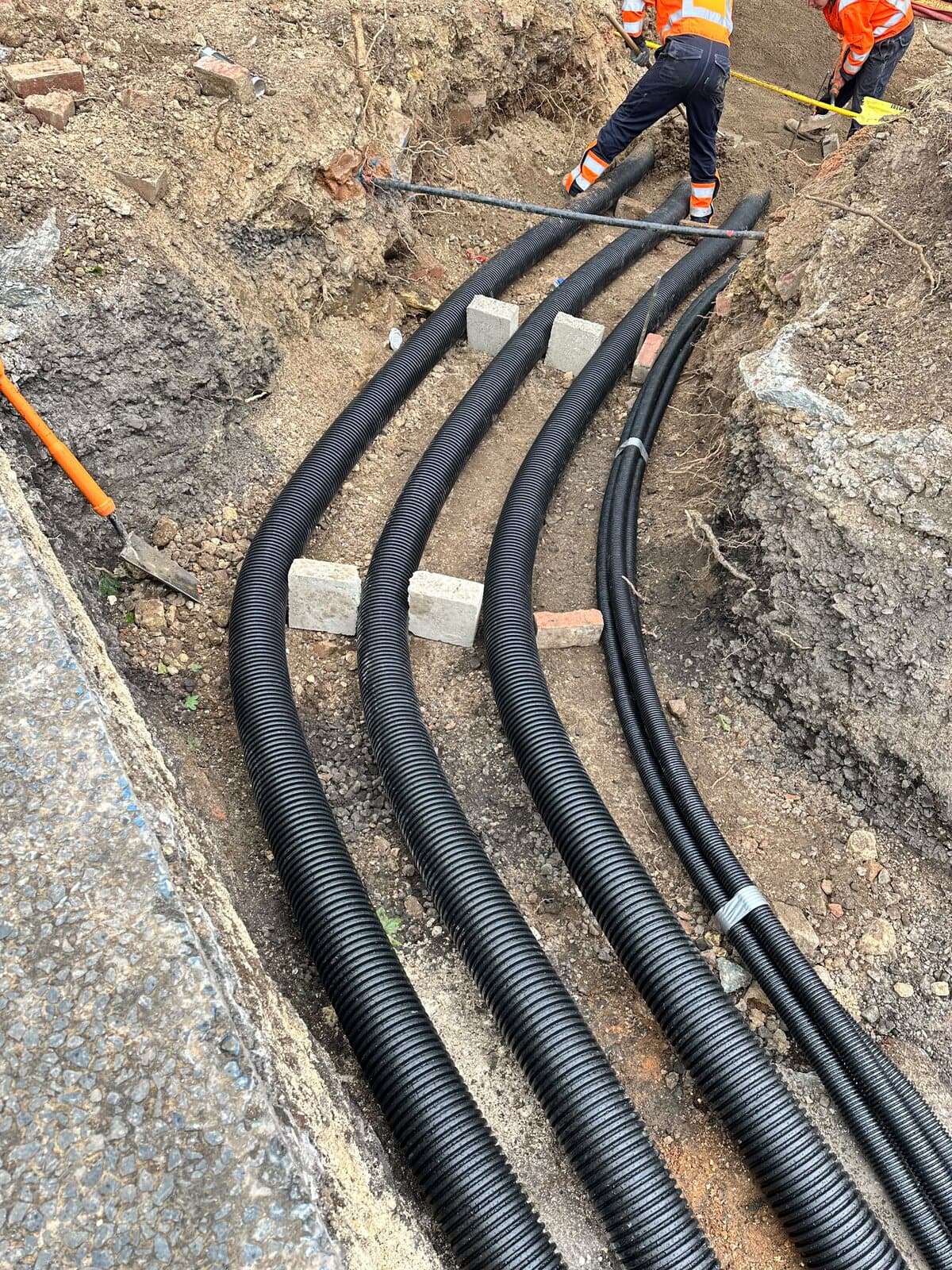 Ducts laid and spaced on blocks through a rock trench before backfilling
