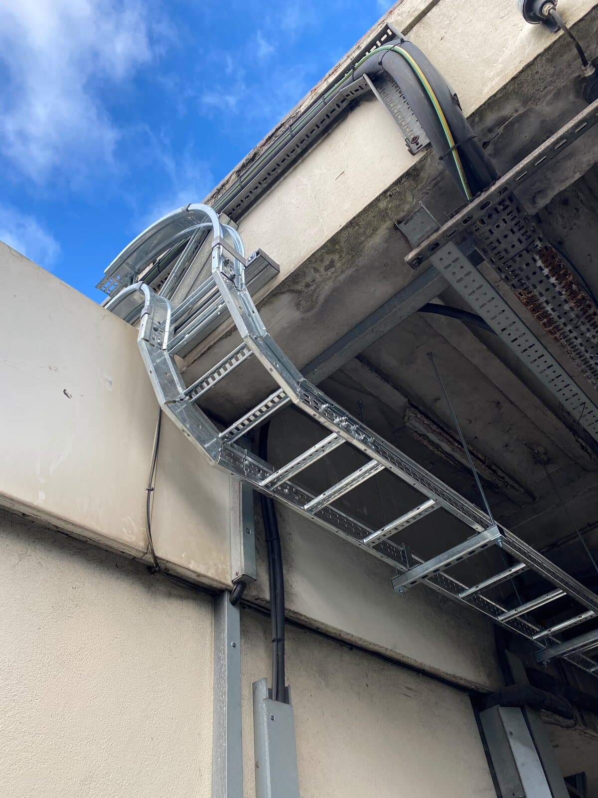 Cable ladder turned around the corner of a building and carried along the wall