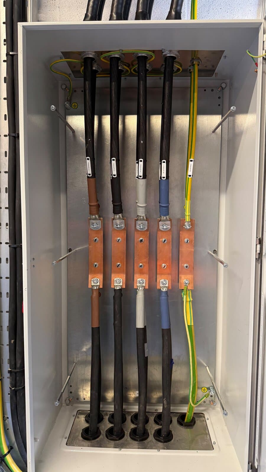 Wall-mounted enclosure with four armoured cables glanded and terminated onto links