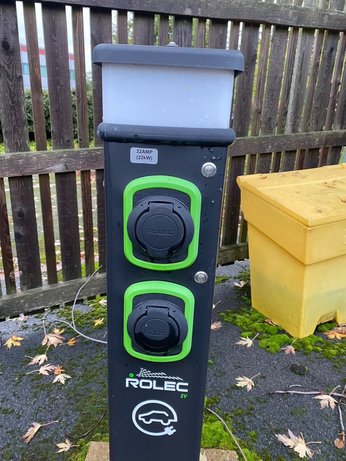 Twin-socket car charging bollard installed beside a driveway, ready to use
