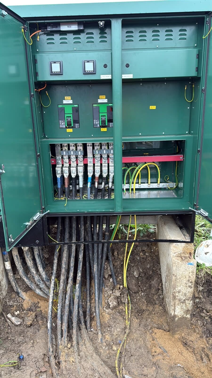 Feeder pillar wired out with fuse switches above and outgoing cables dropping into the ground