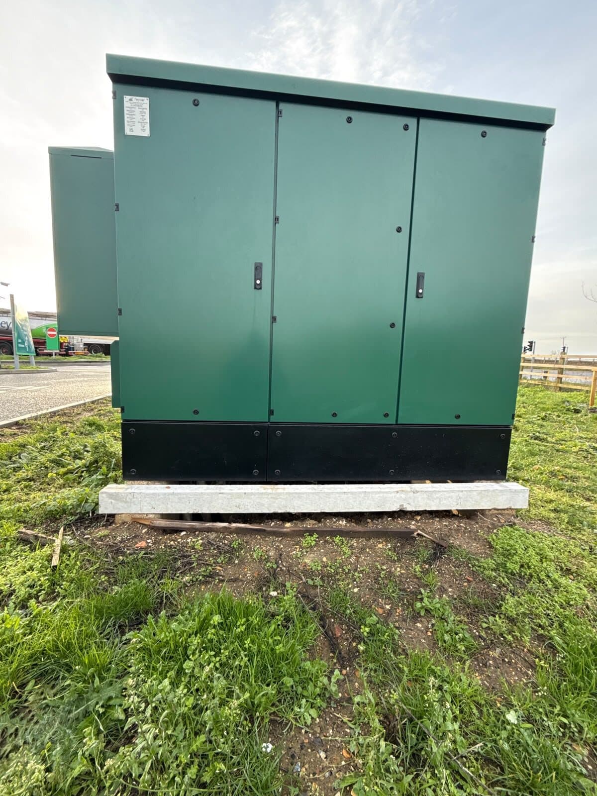 Finished feeder pillar standing on a grass verge, doors closed and the ground made good