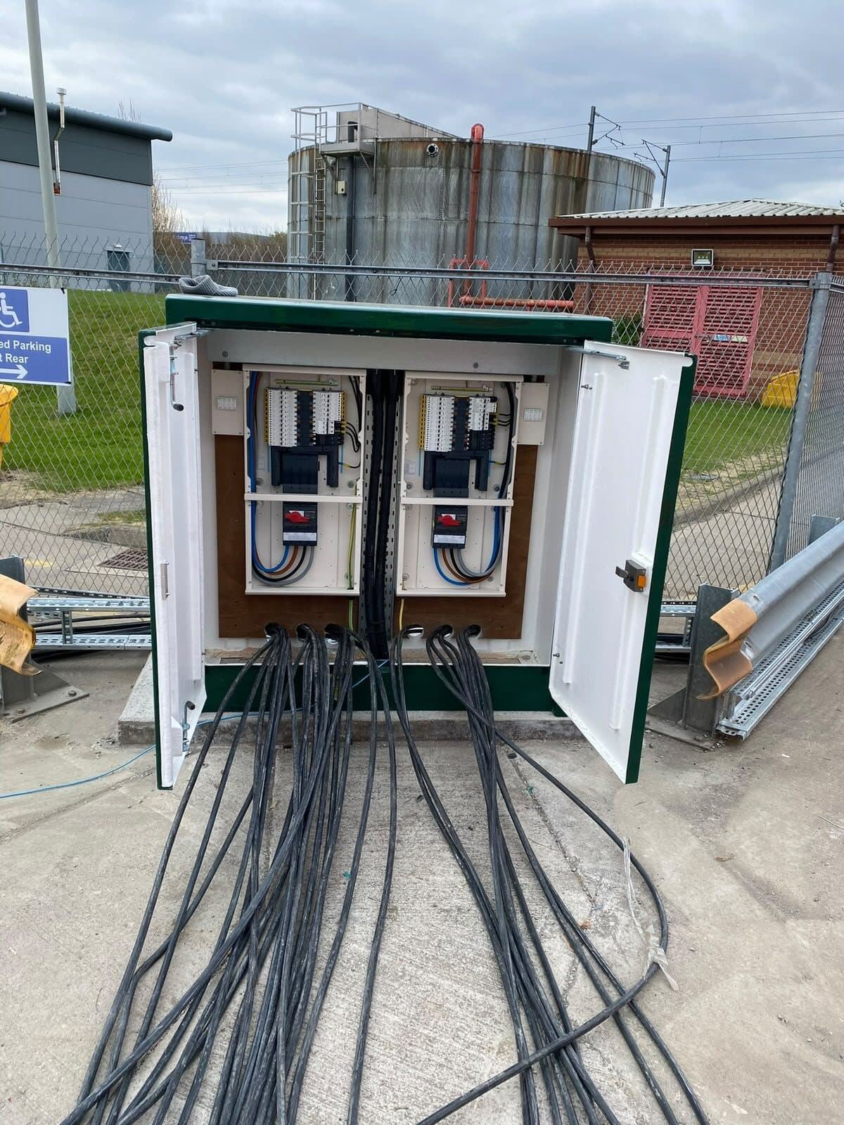 Outgoing cables fanned out across the slab from an open distribution pillar