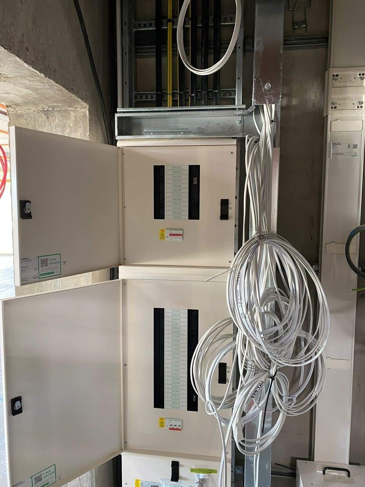 Distribution boards in a riser, wired and ready for the final circuits to be terminated