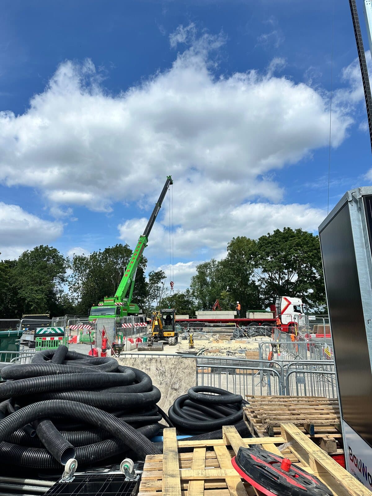 Coils of ducting on site ready to go in, with the crane working behind