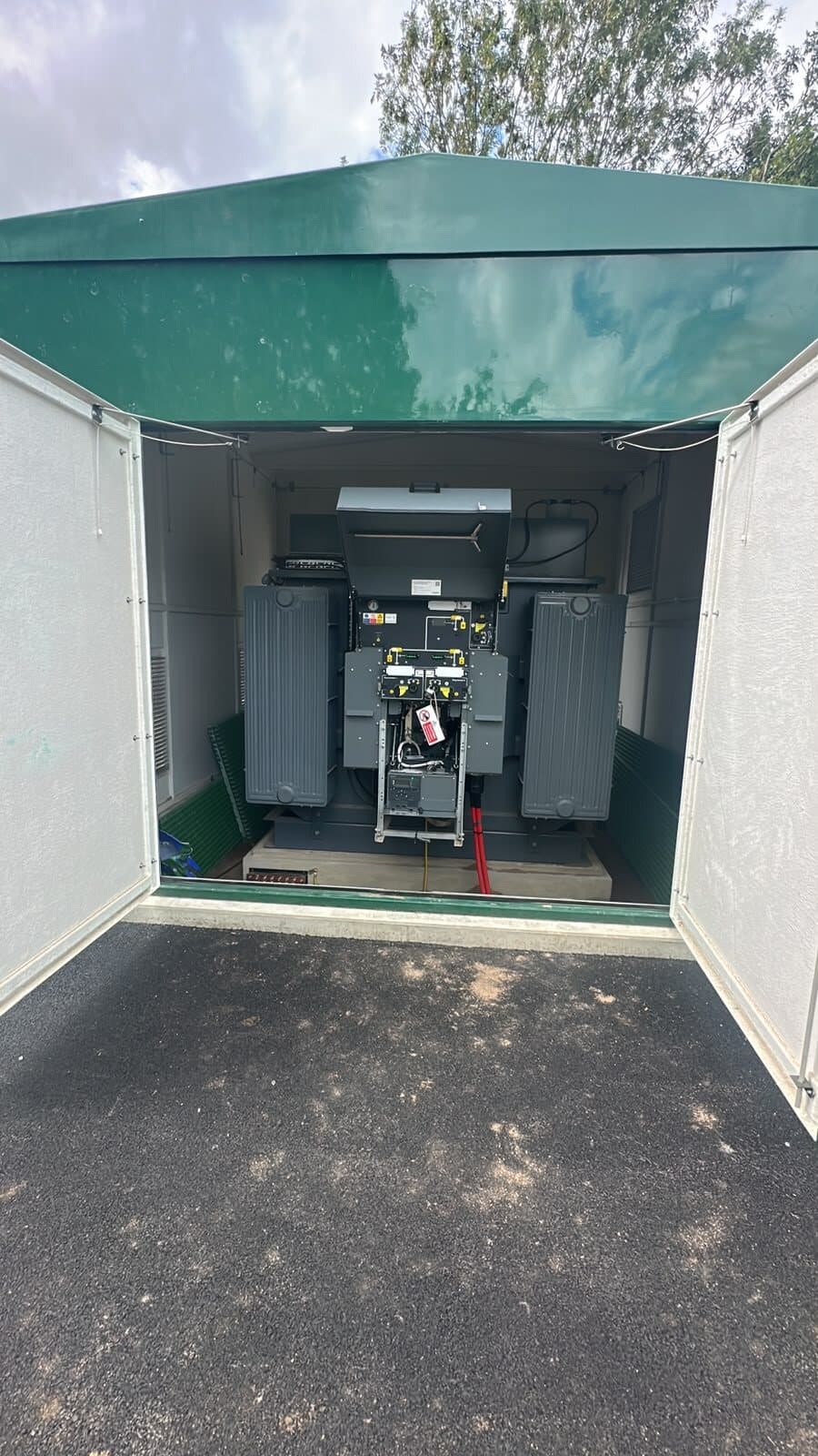 Substation kiosk with the doors open, showing the transformer and switchgear inside