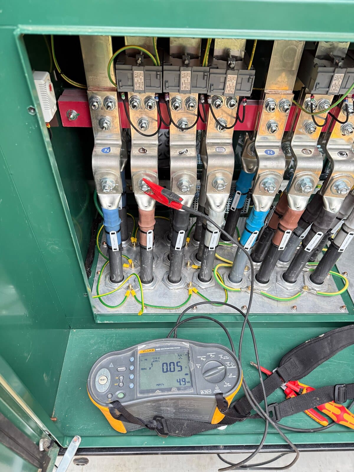 Testing a feeder pillar with a multifunction tester clipped onto the outgoing terminations